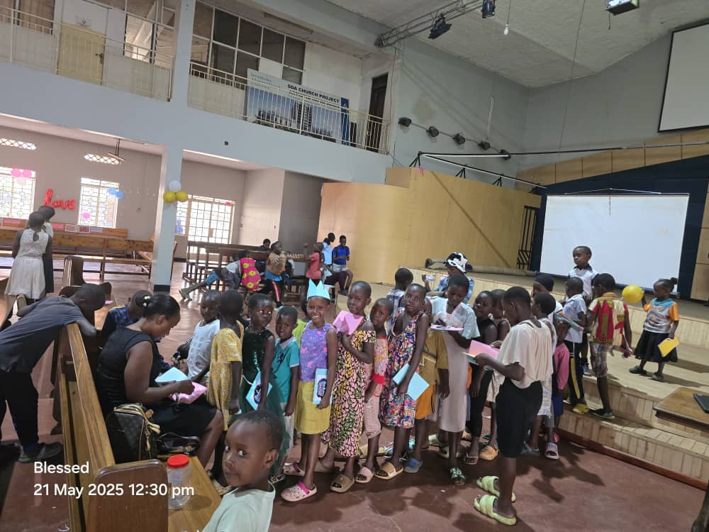 Children with paper crafts in a hall