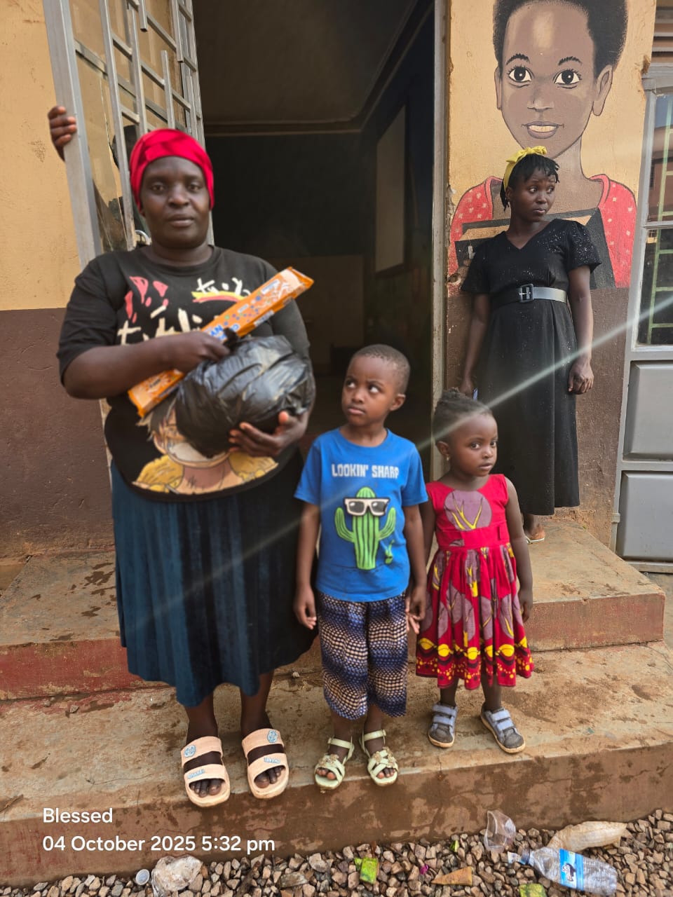 A mother holding food supplies with her two children