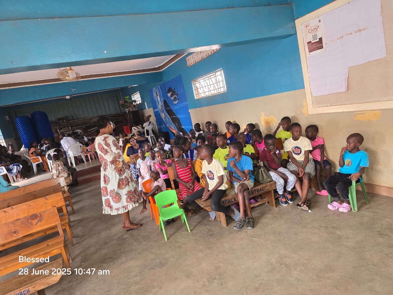A teacher with children in a blue-walled hall
